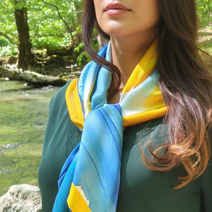 Foulard onde solaire porté autour du cou, soie satin et art fluide bleu et jaune